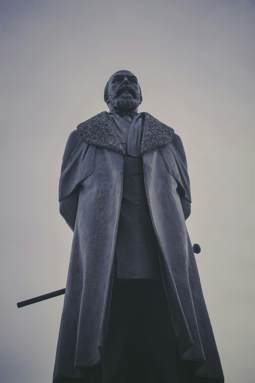 a statue of a man wearing a coat and holding a sword