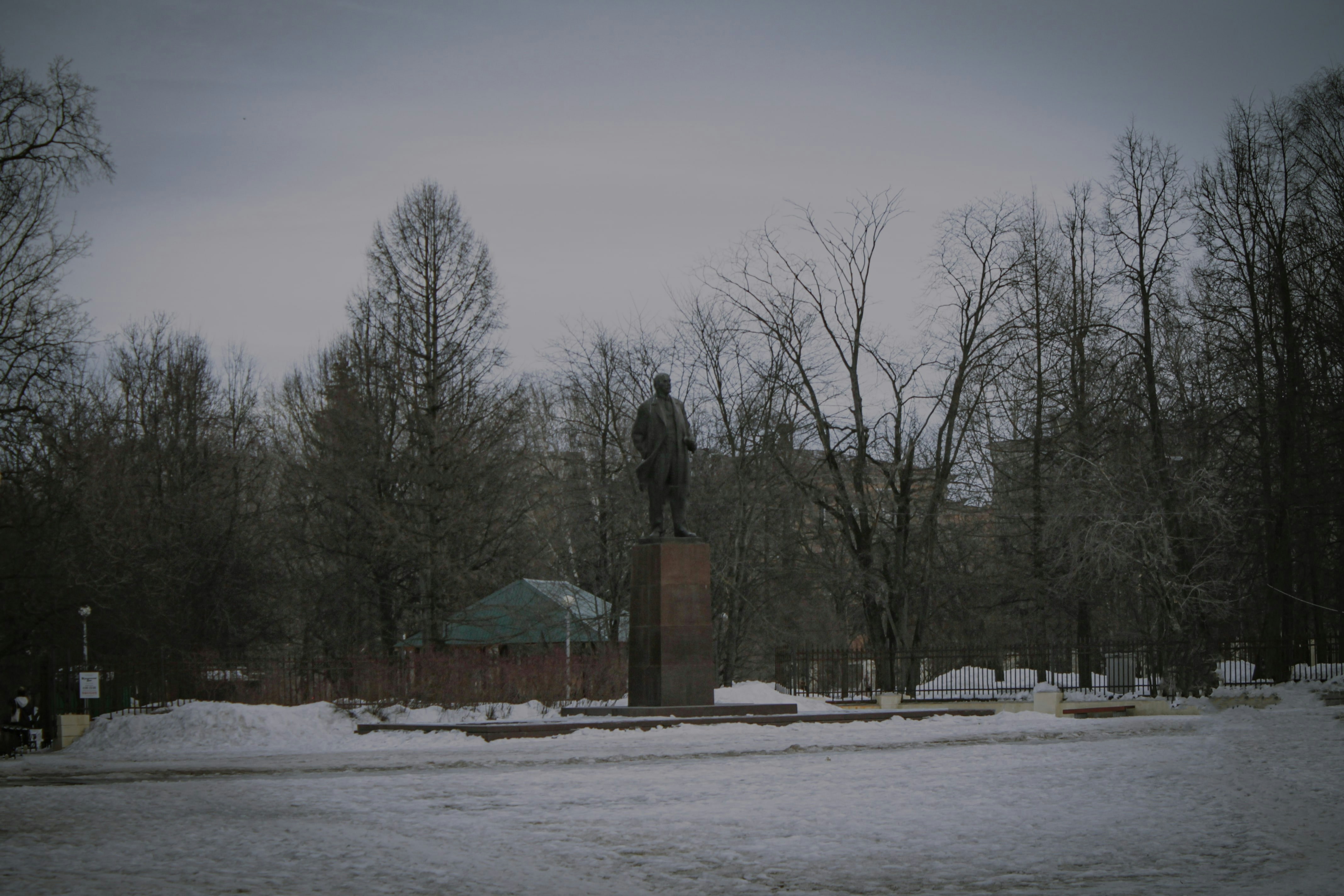 a statue in the middle of a snowy park