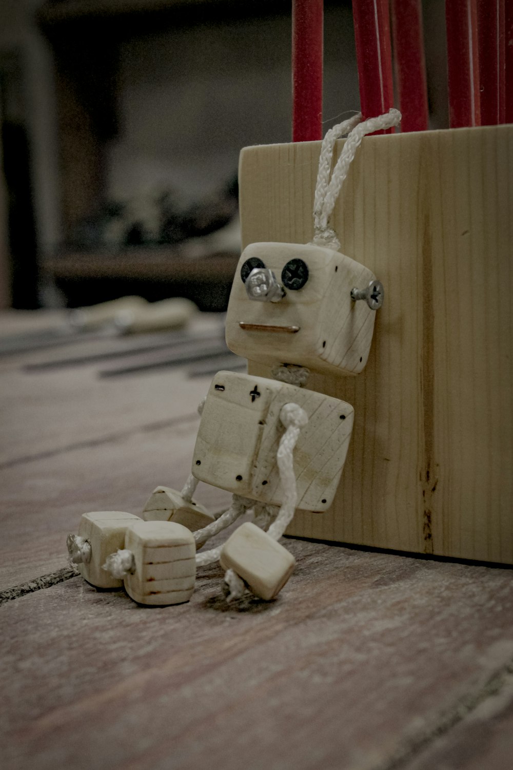 a robot made out of wood sitting on top of a wooden floor