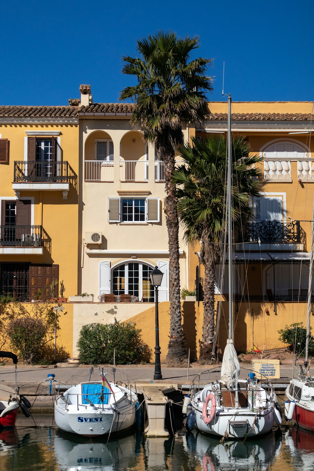 a group of boats sitting next to a yellow building