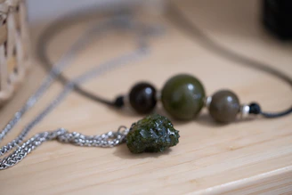 a couple of necklaces sitting on top of a wooden table
