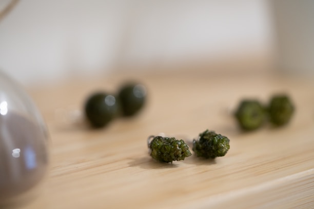 Close-up of polished jade stones glowing under soft green neon lighting.