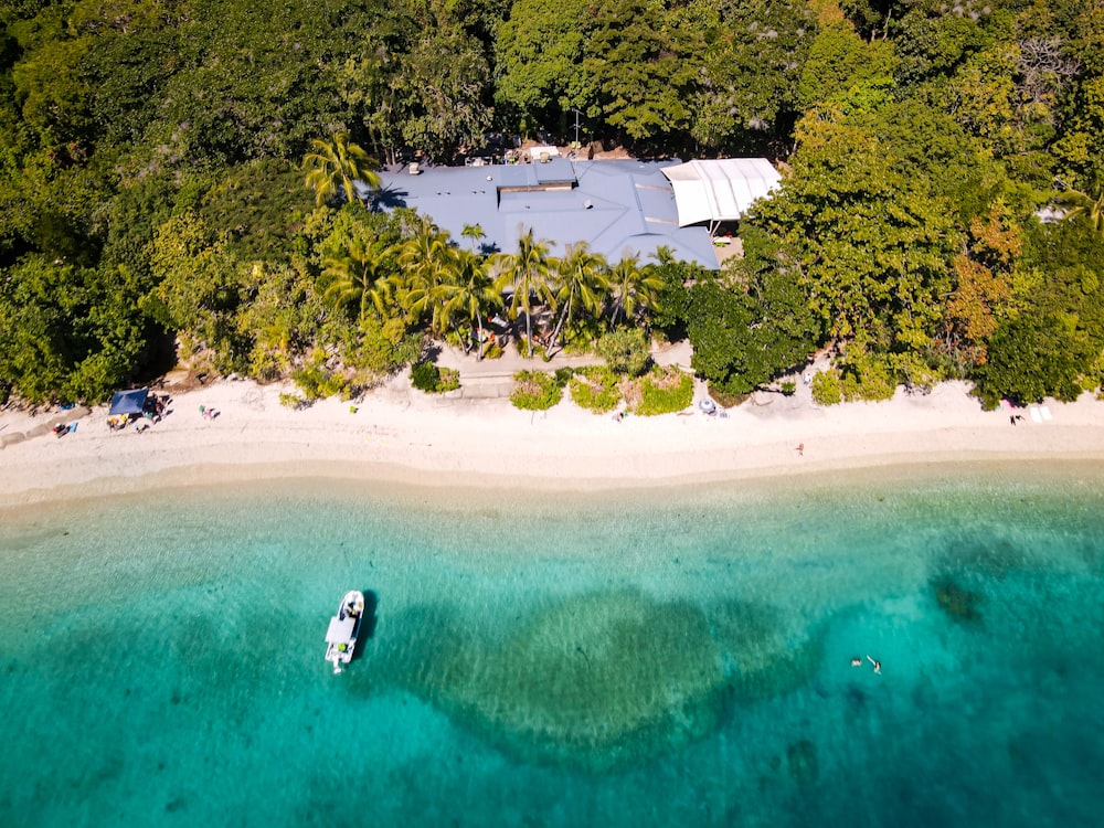 uma vista aérea de uma praia com um barco na água