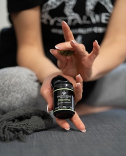 A hand holding a small one-gram bag of premium cannabis flower with a sleek label.