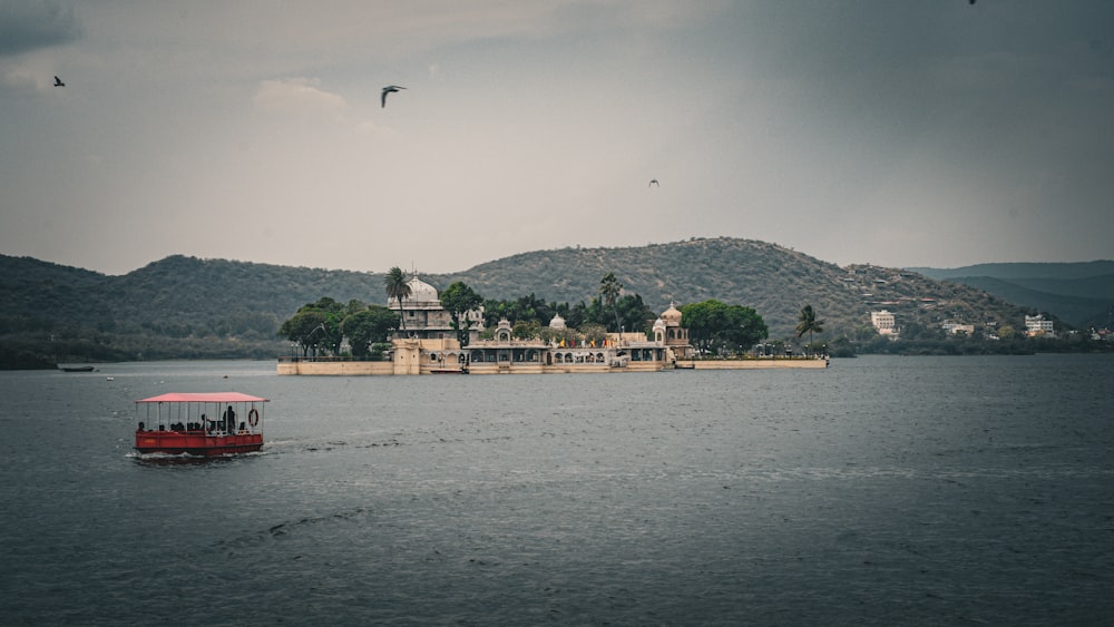 a red boat in the middle of a lake