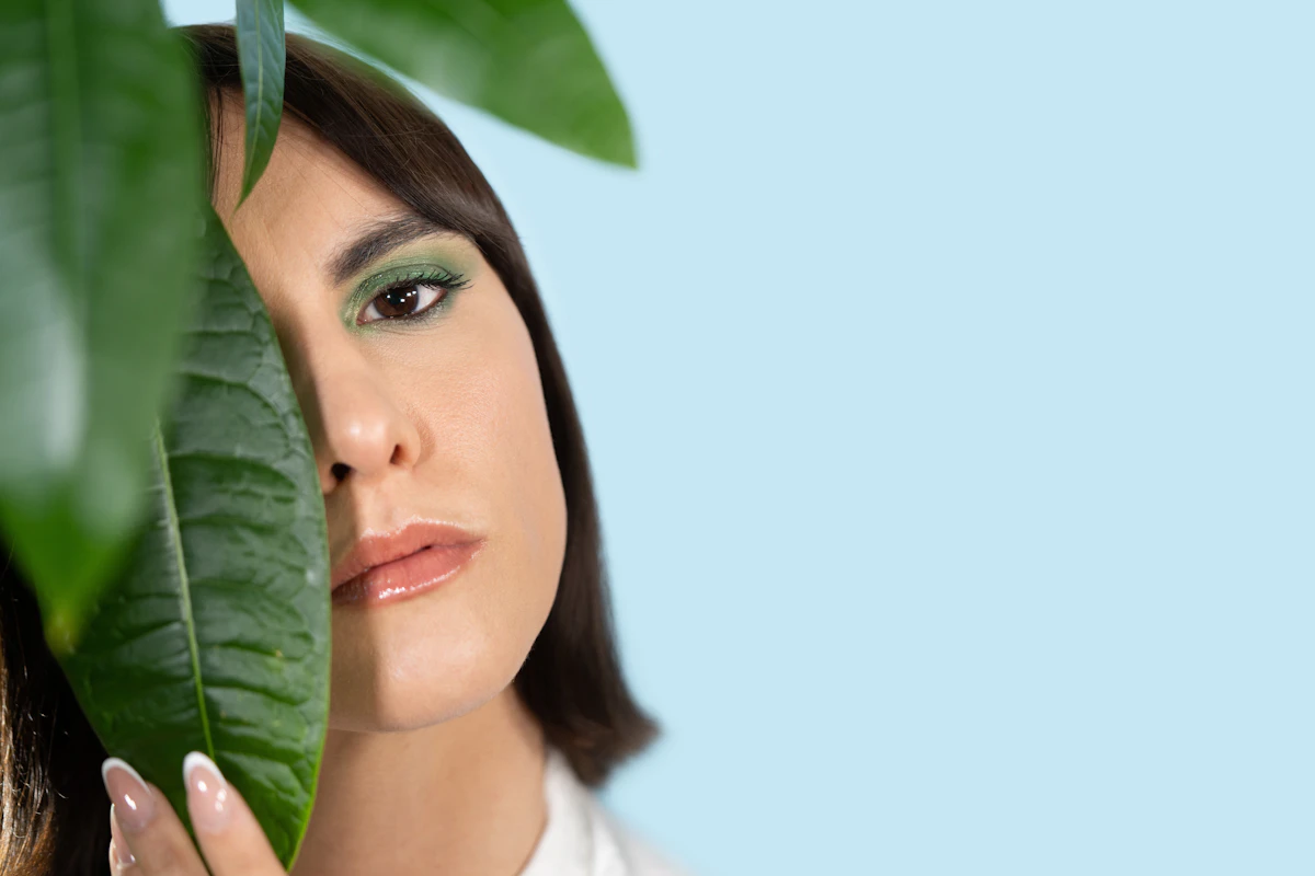 Woman with a fresh, defined face among green leaves – puffy face treatment at JIA Skin Clinic Seoul