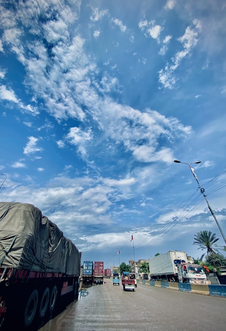 A busy transport hub with trucks and cargo being loaded under a clear sky