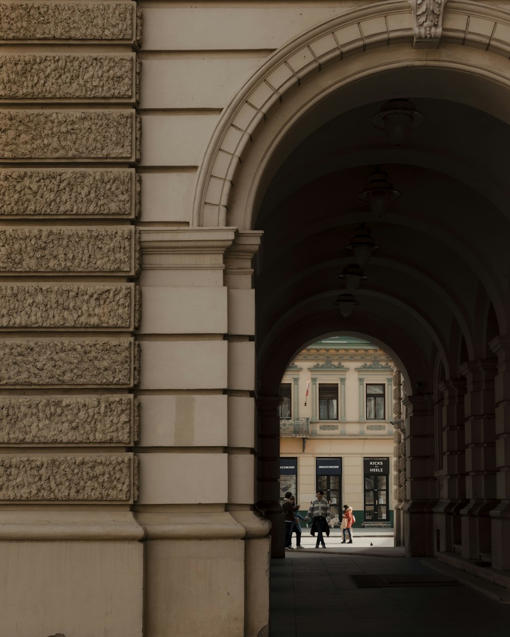 a couple of people that are standing under an arch