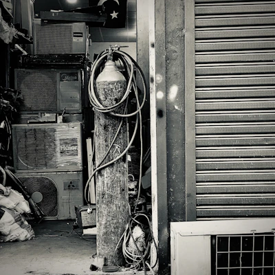 A neatly stacked pile of used air conditioners ready for resale in a Delhi warehouse.