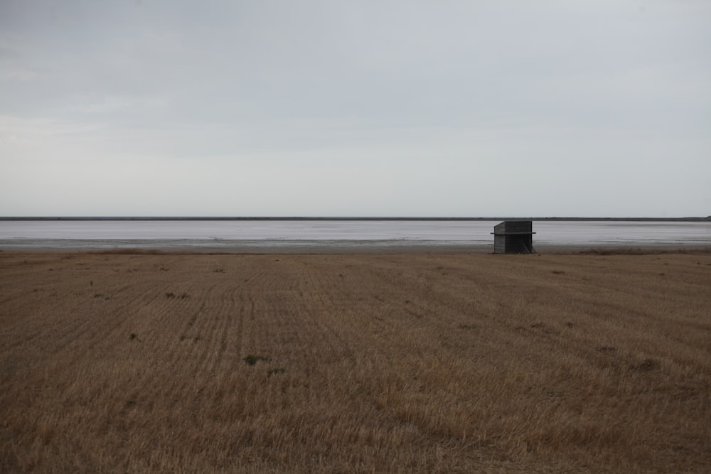 a field with a trash can in the middle of it