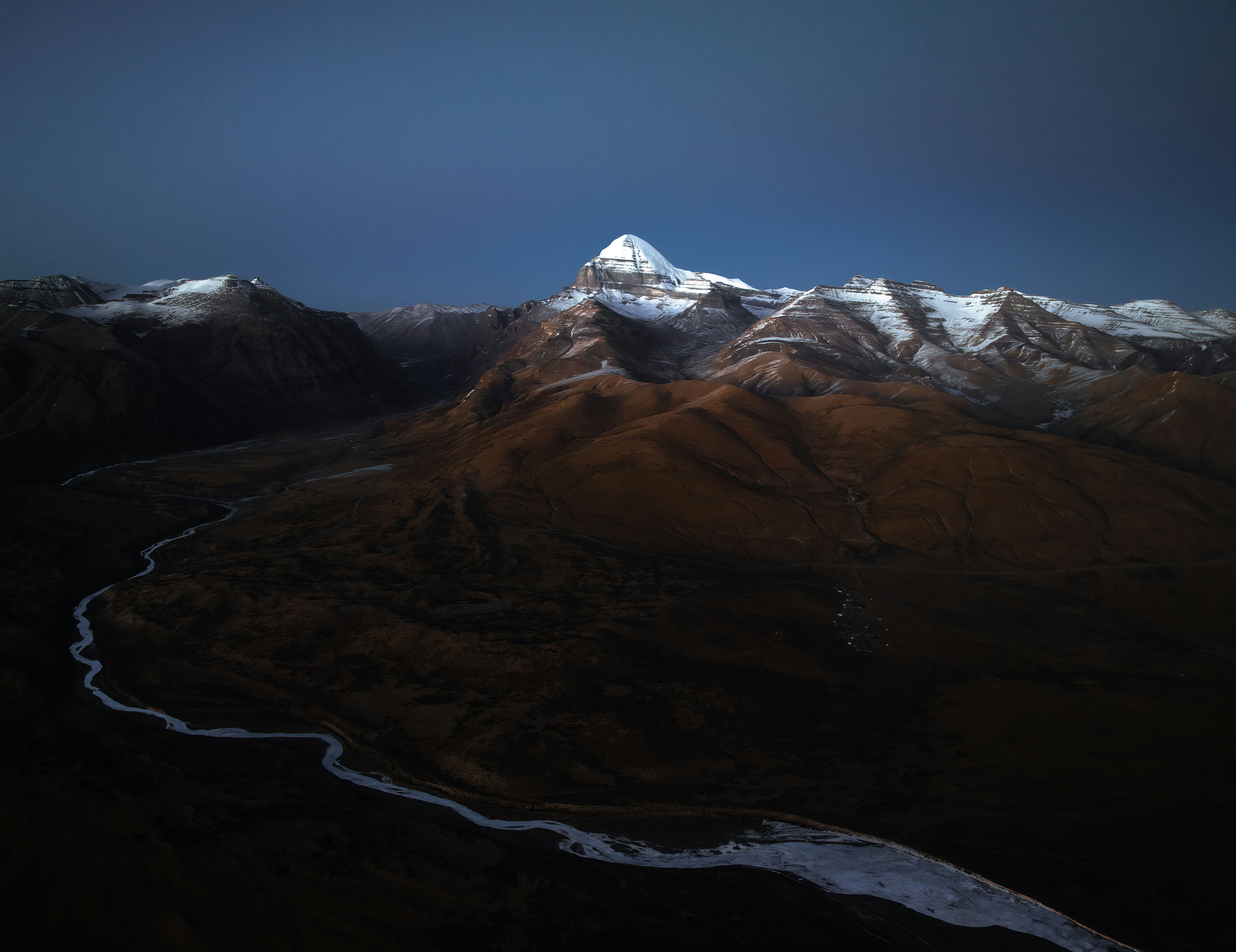 a snow covered mountain with a river running through it