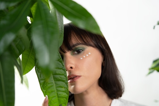 a woman with a green eyeliner and a green leaf