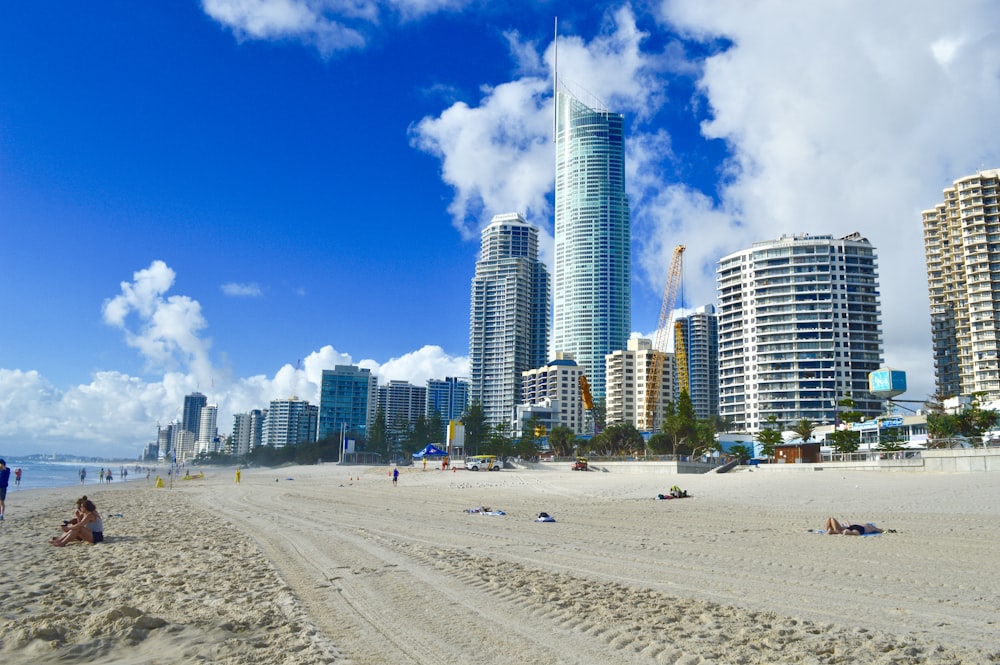 a beach with people and buildings in the background