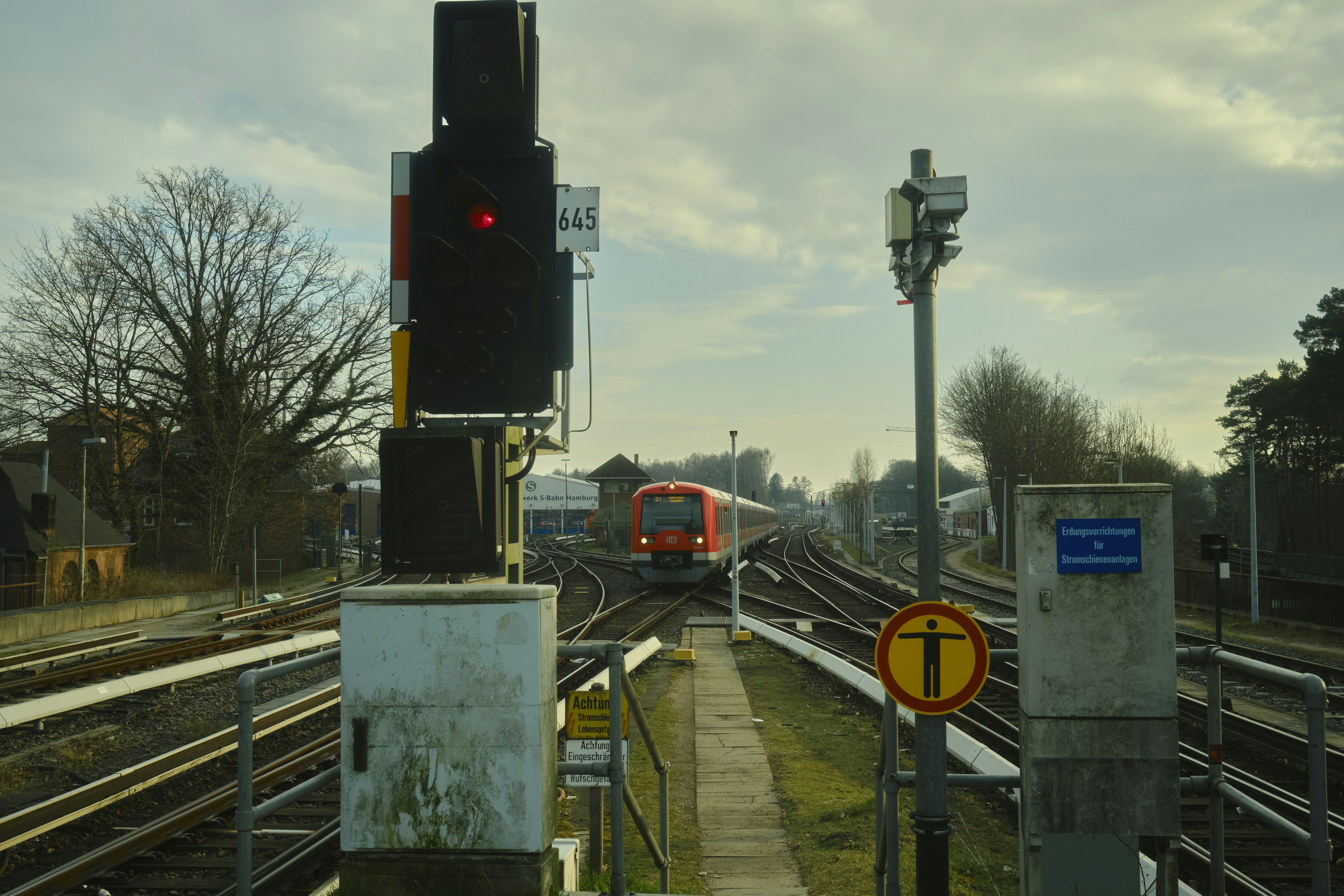 a train traveling down train tracks next to a traffic light, 