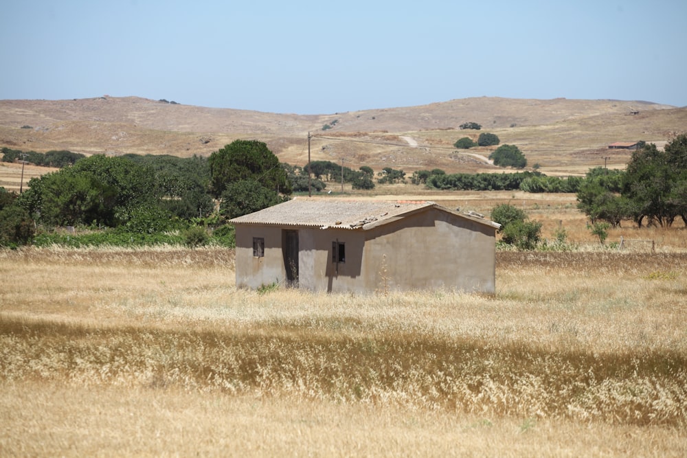 a small building in a field of dry grass