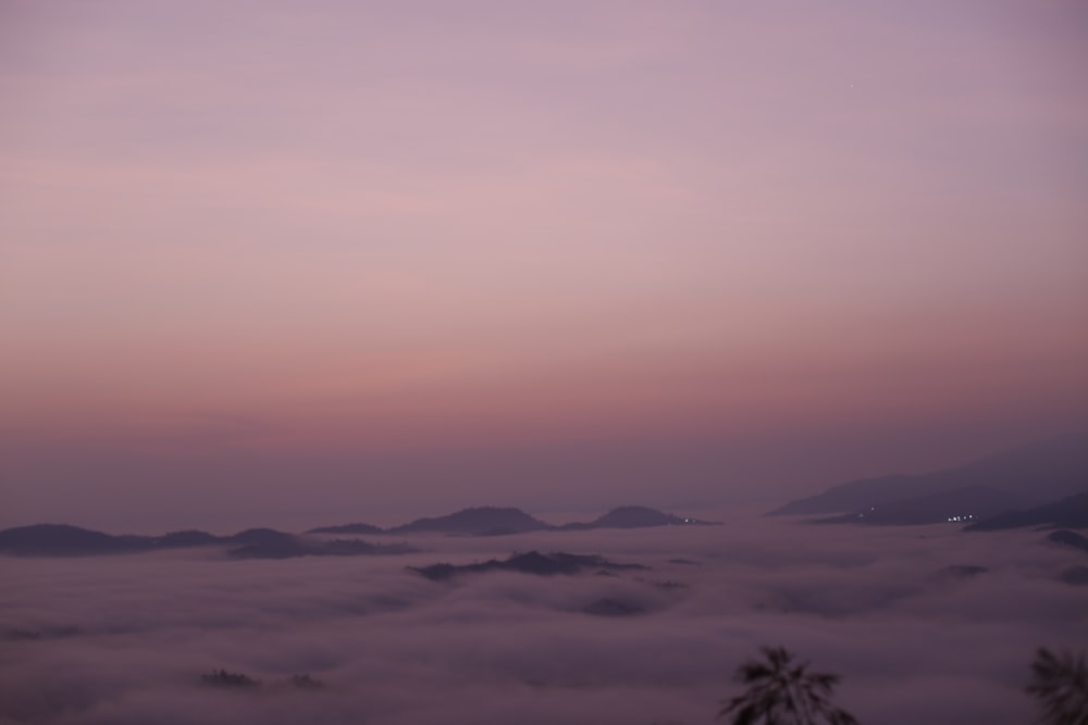 a view of a foggy valley at dusk