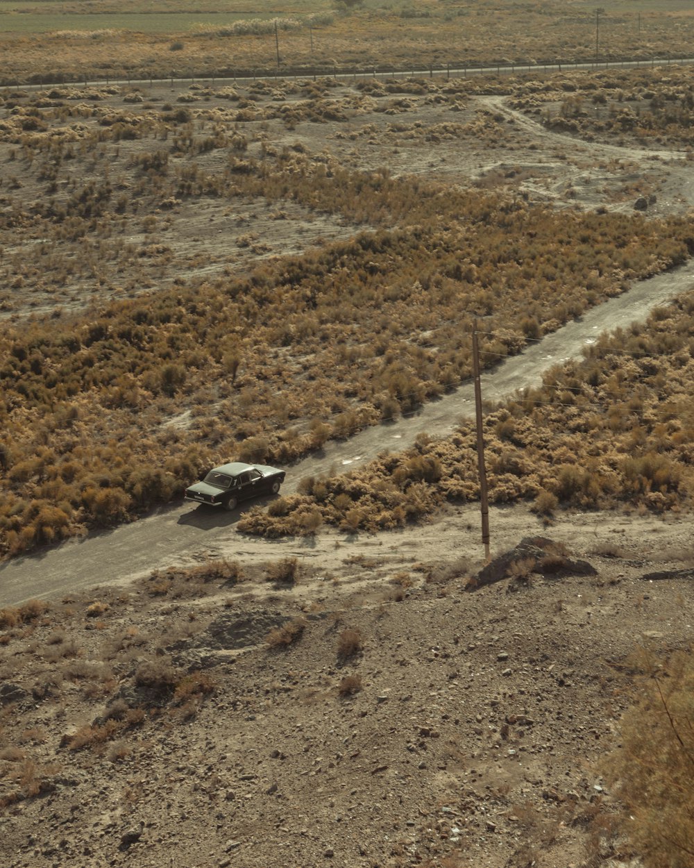 a car is parked in the middle of the desert