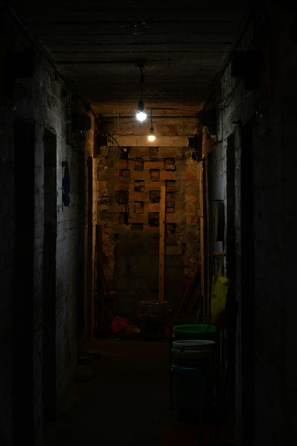 a dark hallway with a light hanging from the ceiling