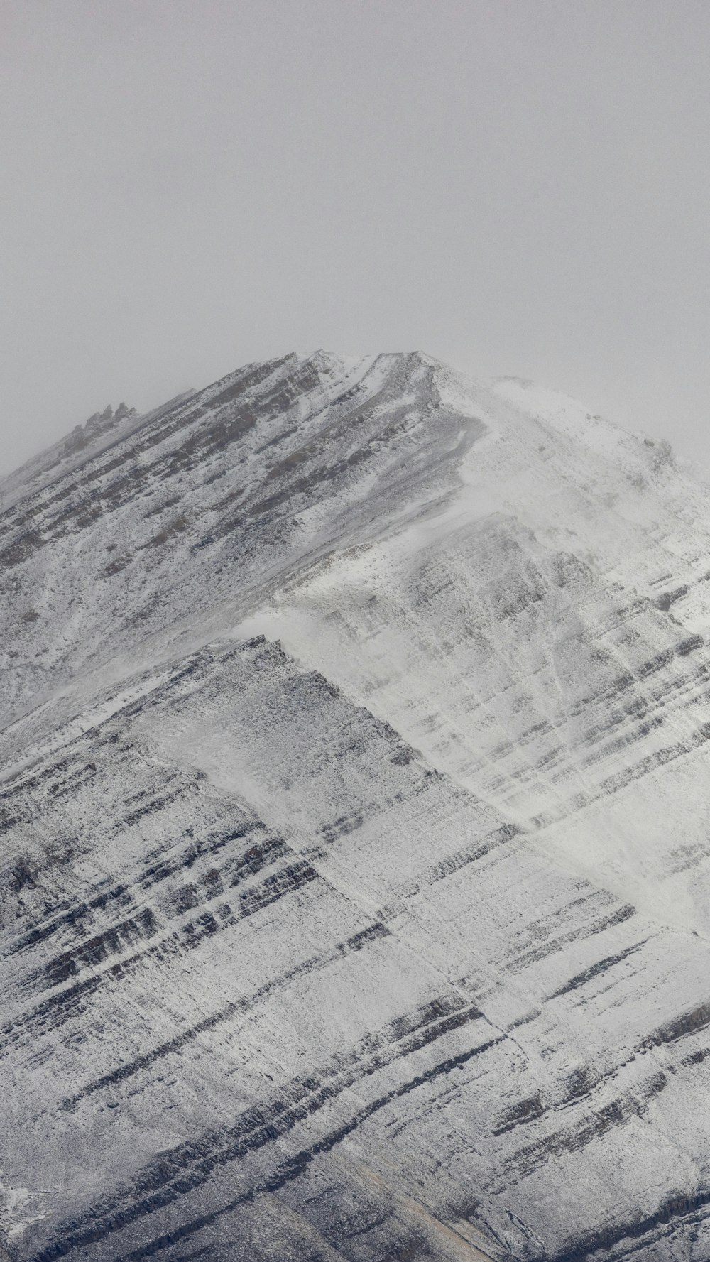 a snow covered mountain with a snowboarder in the foreground