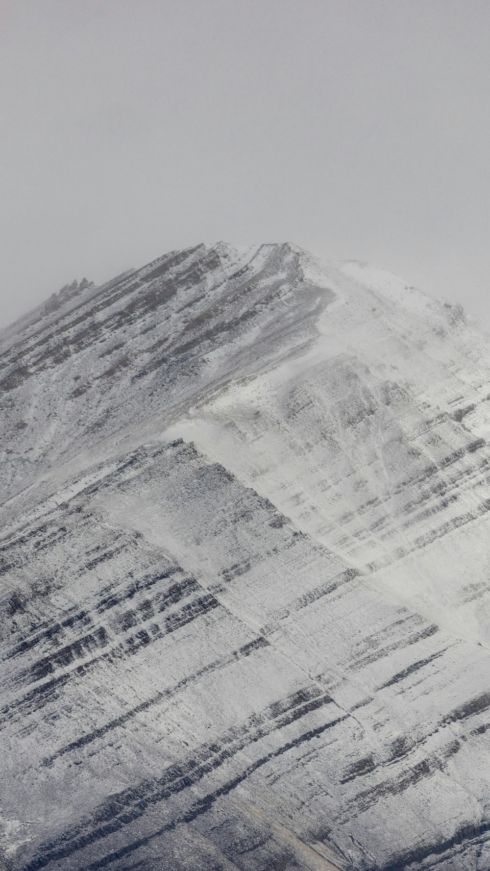Ein schneebedeckter Berg mit einem Snowboarder im Vordergrund