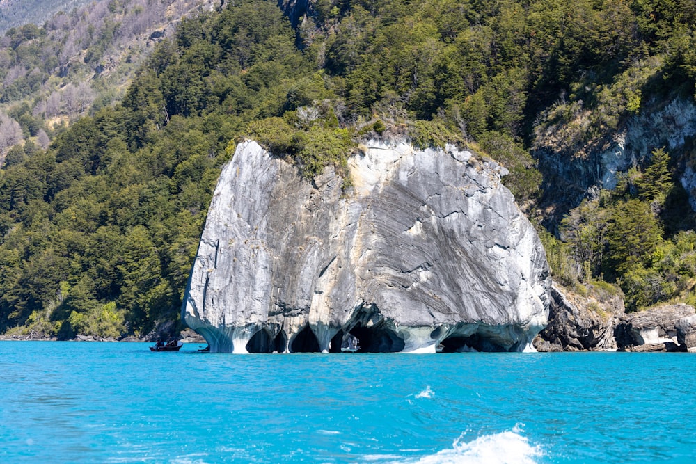 a large rock formation in the middle of a body of water