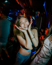 A confident person enjoying a lively party with friends, glowing under soft lights.