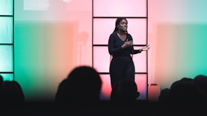 a woman standing on a stage with a microphone