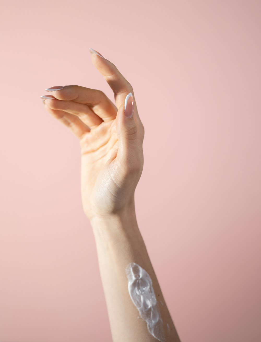 a woman's hand with a white manicure on it