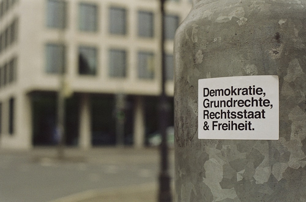 a sticker on a pole in front of a building