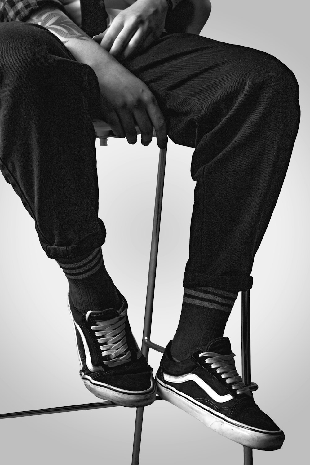 a black and white photo of a person sitting on a stool