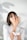 A person with short dark hair is applying cream to their face using their fingers. They are holding an open jar of skincare product in their other hand. The person is wearing a white shirt, and there is a soft focus shadow in the background.