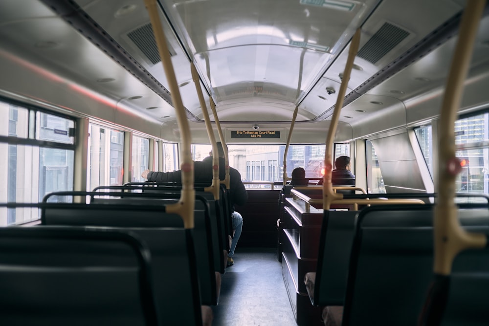 the inside of a bus with people sitting on the seats