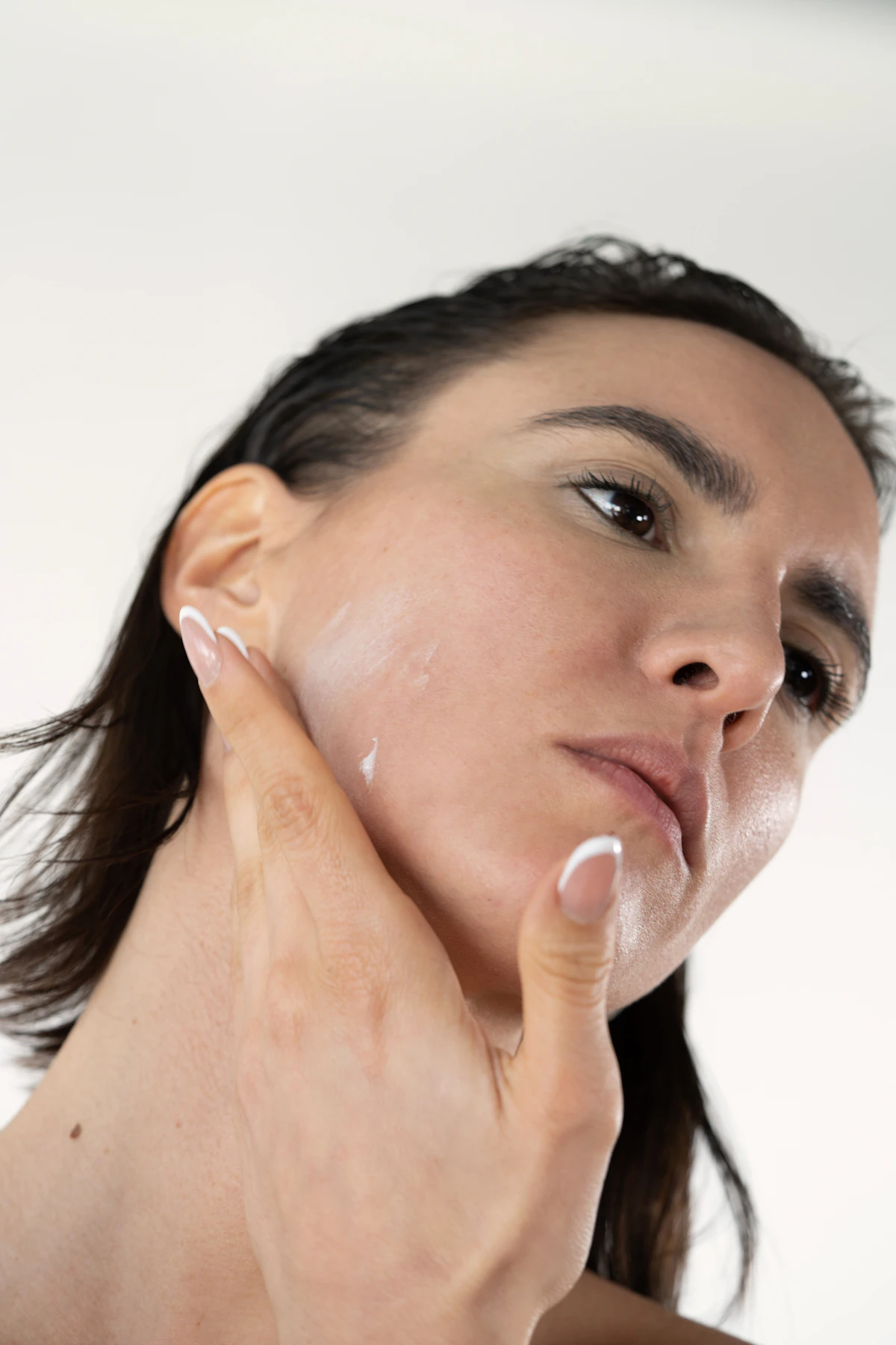 Woman applying a rich night cream to her face