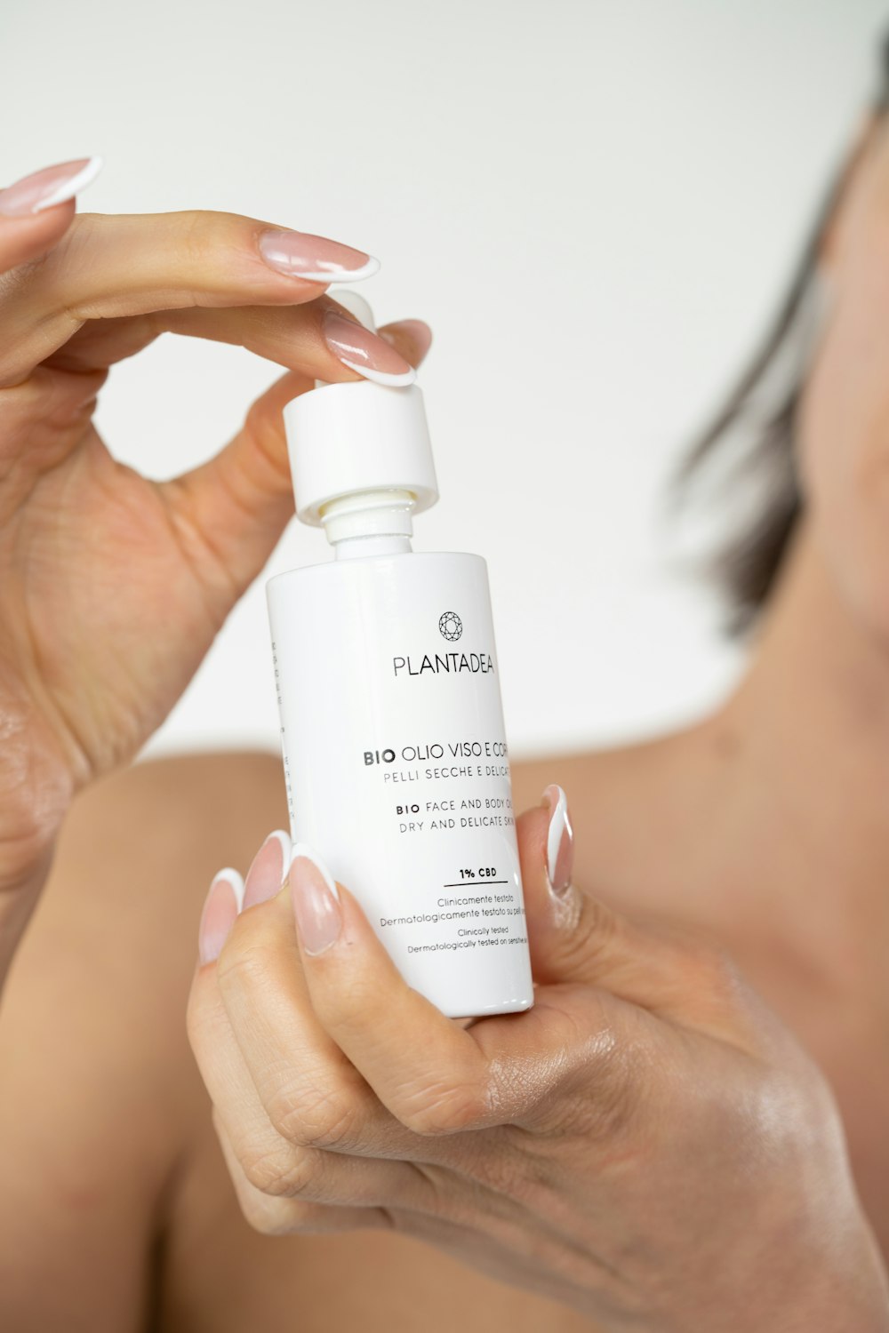 a woman holding a bottle of skin care product