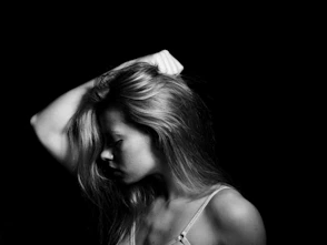 a black and white photo of a woman with her hand on her head