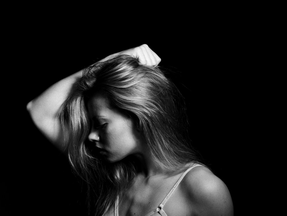 a black and white photo of a woman with her hand on her head