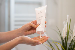a person holding a tube of cream in their hand