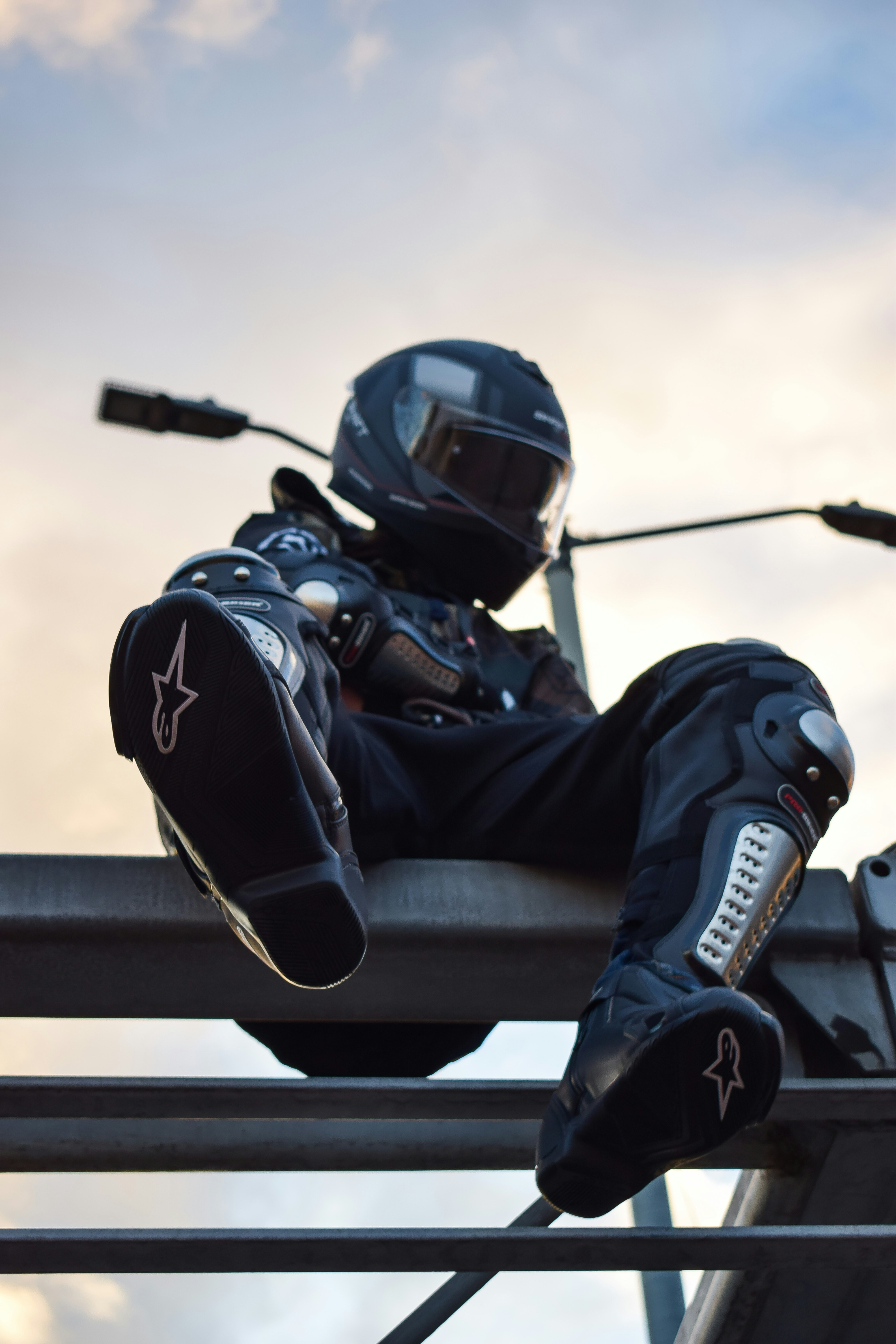 a man sitting on top of a metal rail
