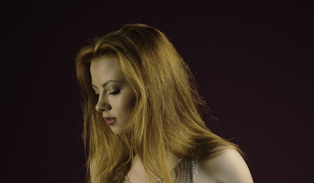 a woman with long red hair is looking down