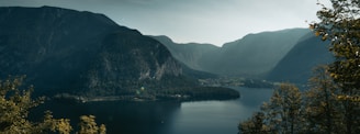 A serene landscape with a calm lake surrounded by mountains and trees, representing tranquility and wellness.