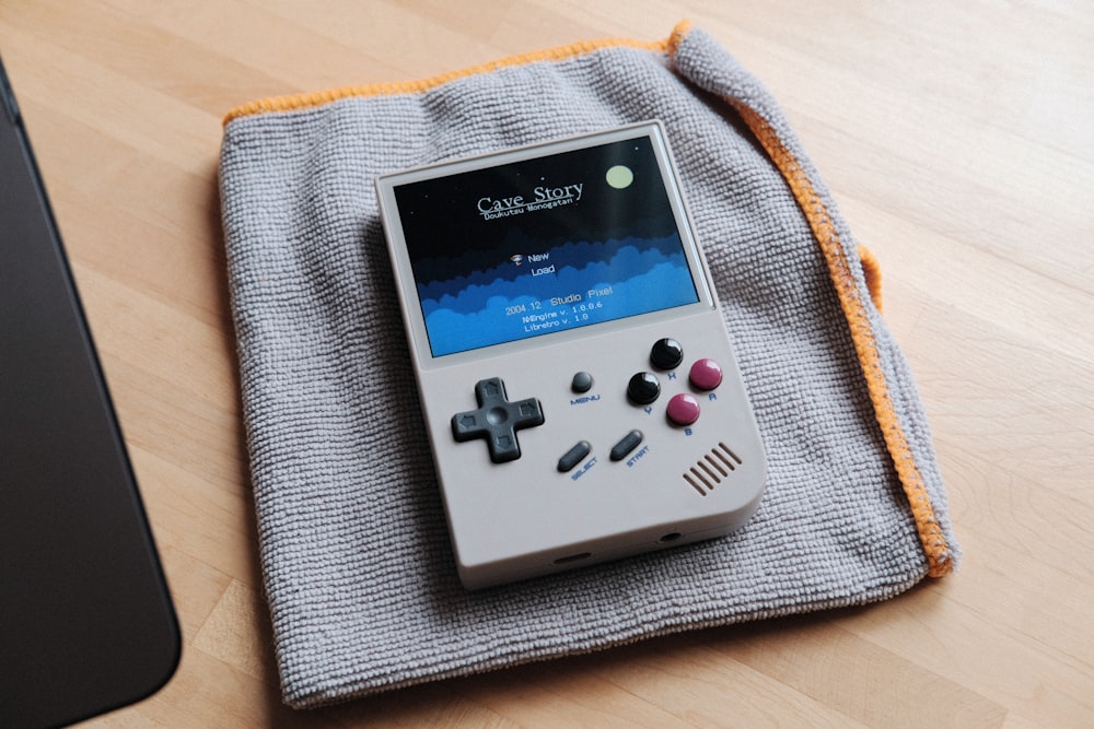 a nintendo game boy sitting on top of a blanket