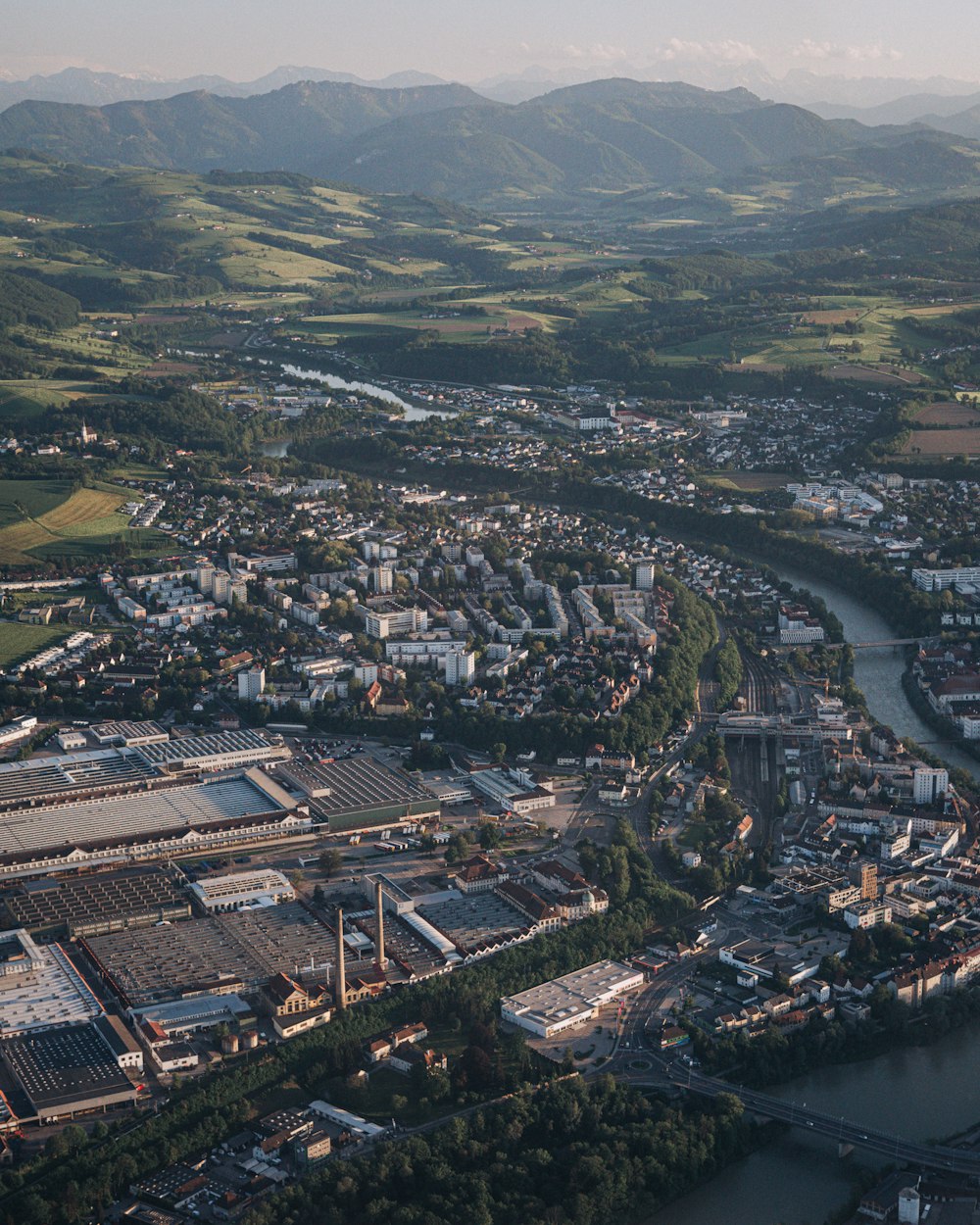 an aerial view of a city with mountains in the background