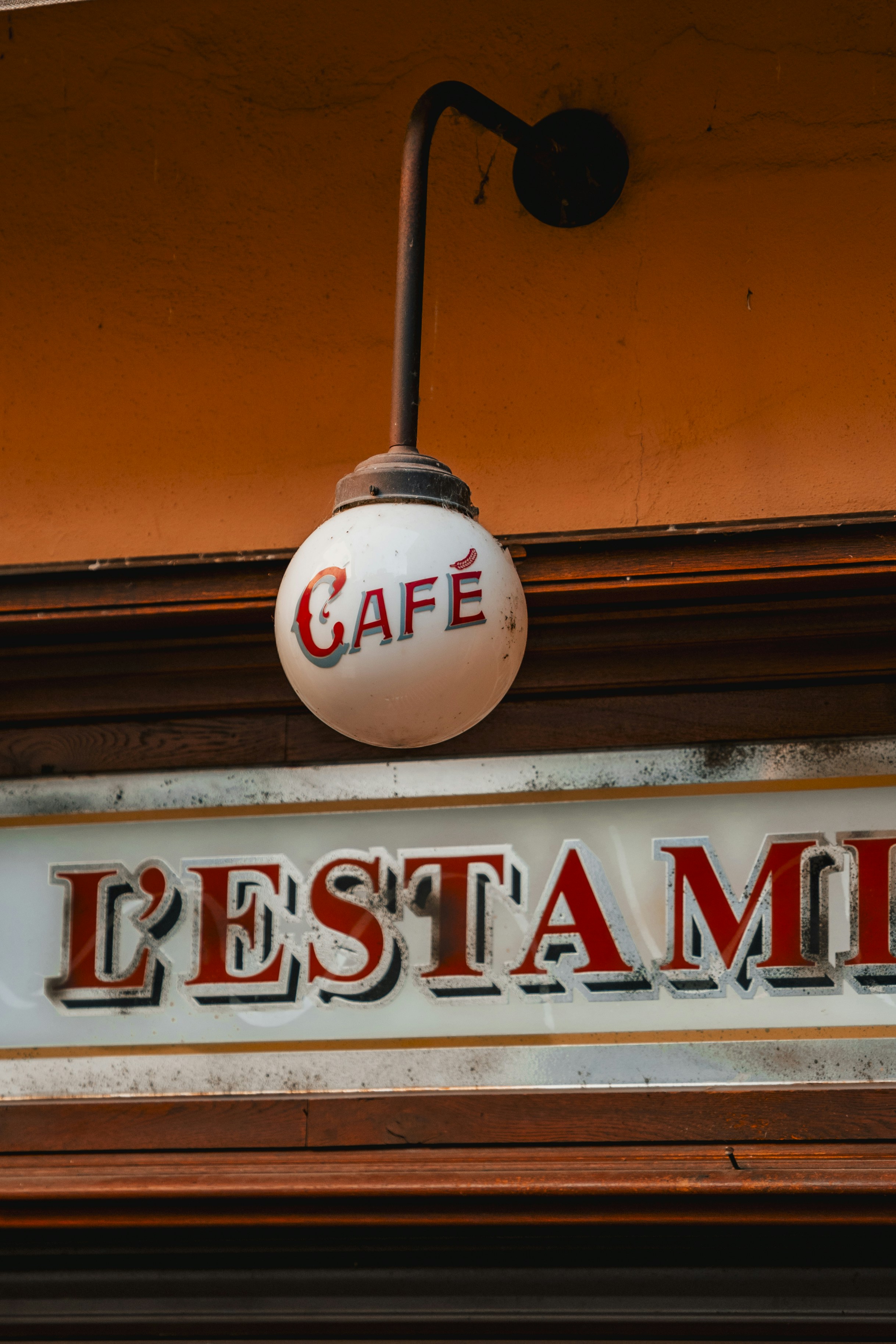 a restaurant sign hanging from the side of a building