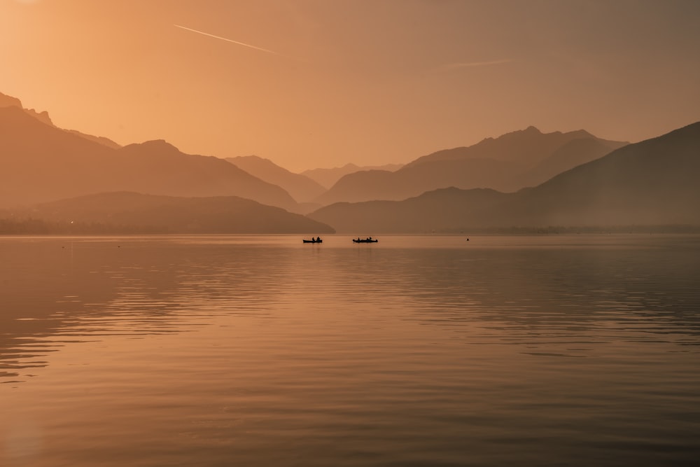 a couple of boats floating on top of a lake