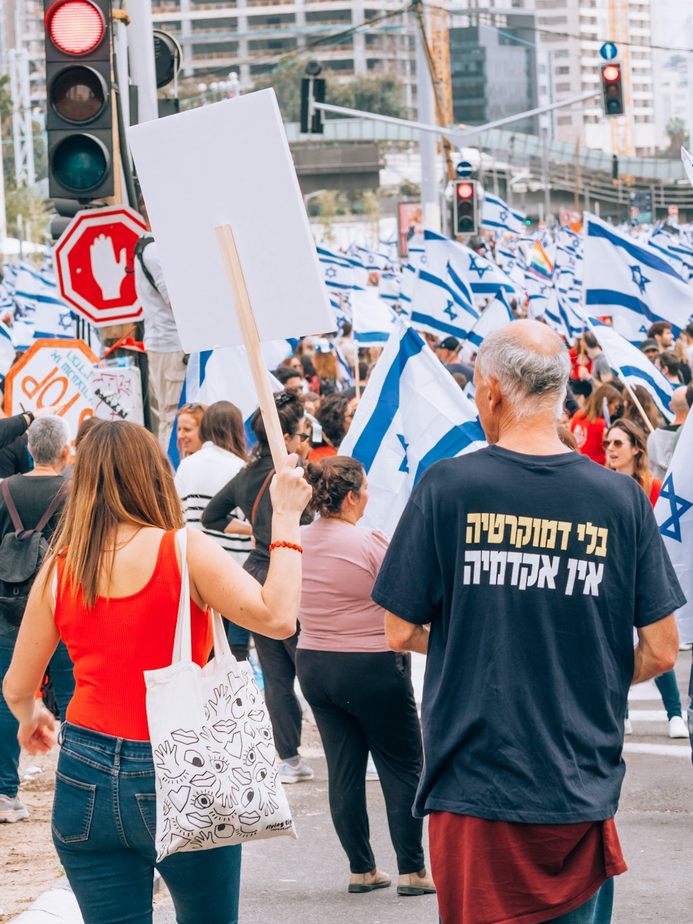 a group of people walking down a street holding signs