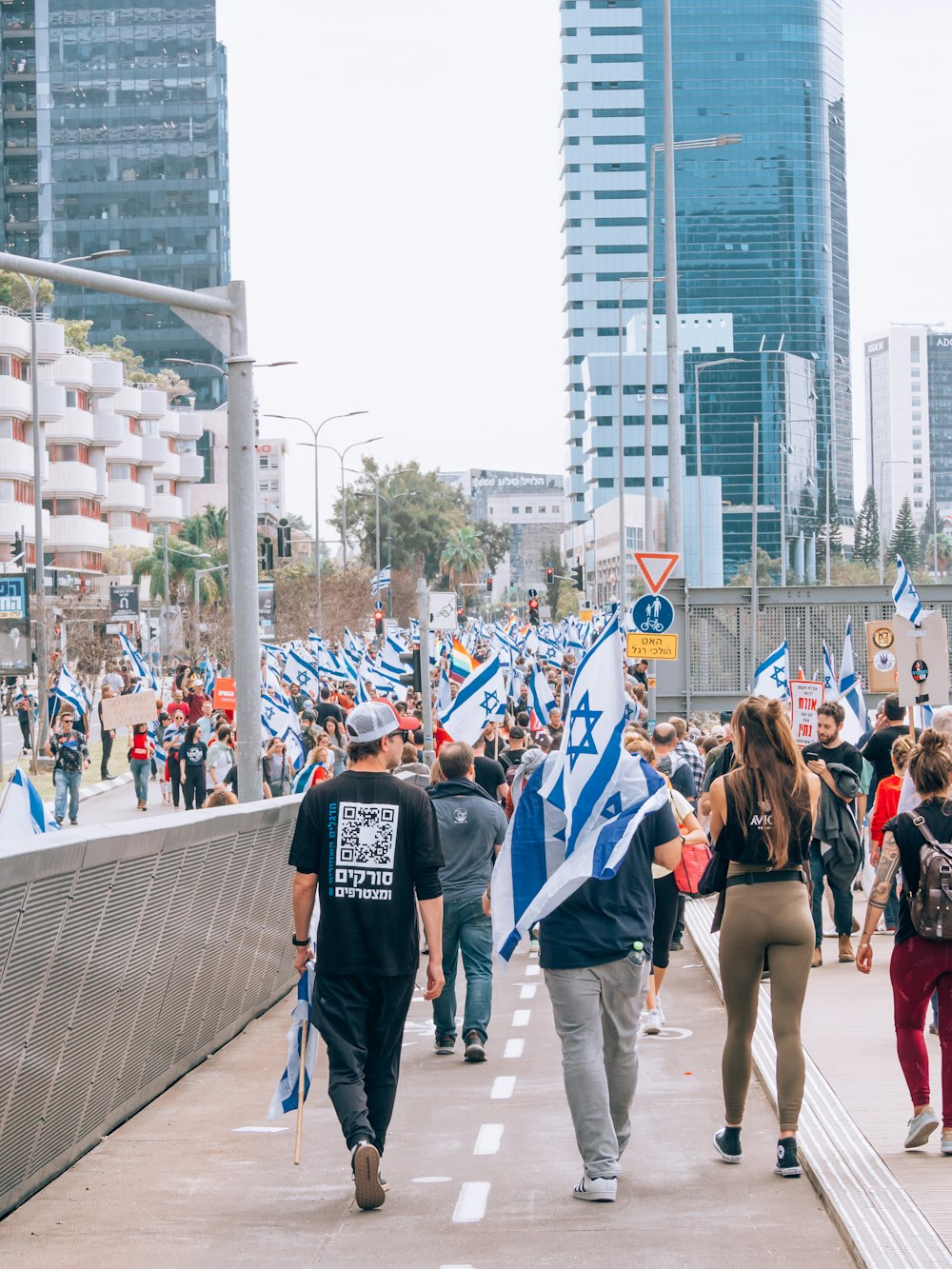 a group of people walking down a street holding flags