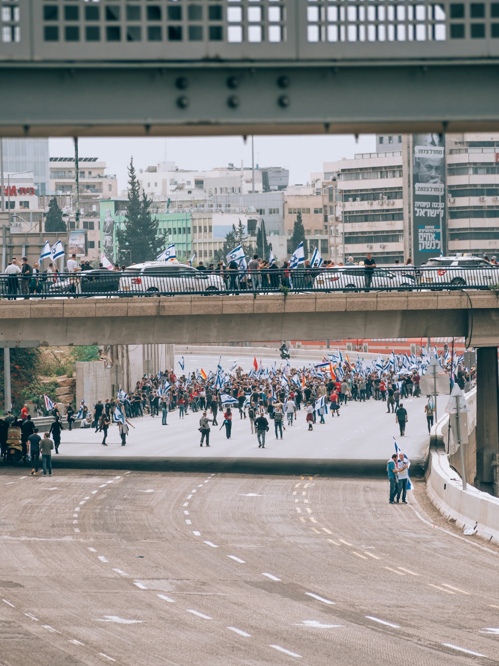 a crowd of people walking across a bridge