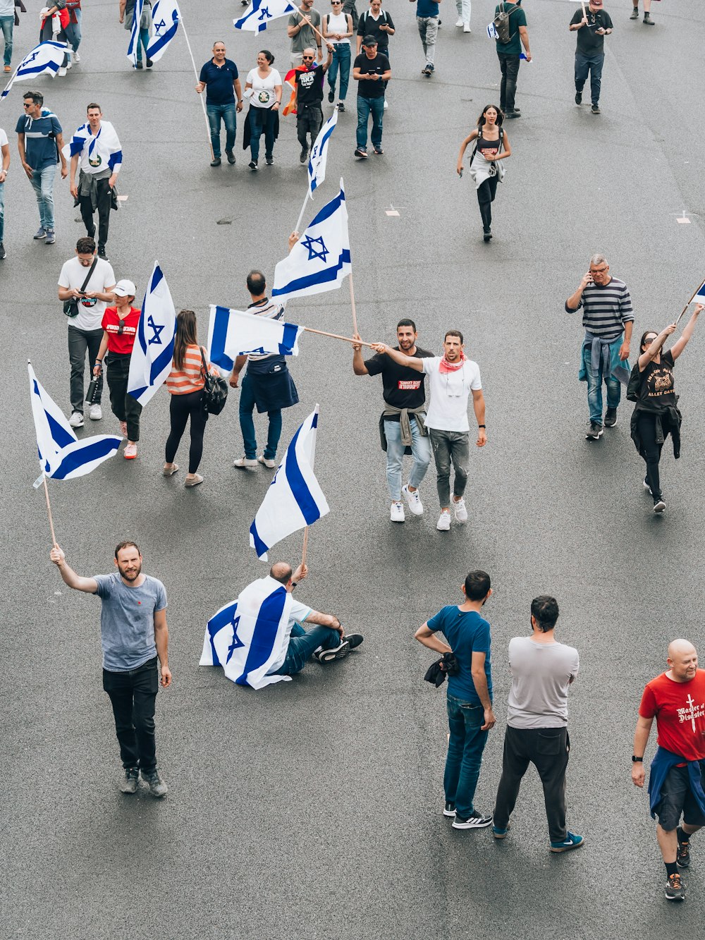 a group of people walking down a street holding flags