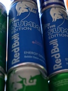 Energy drink cans with dynamic, bold designs displayed on a shelf.