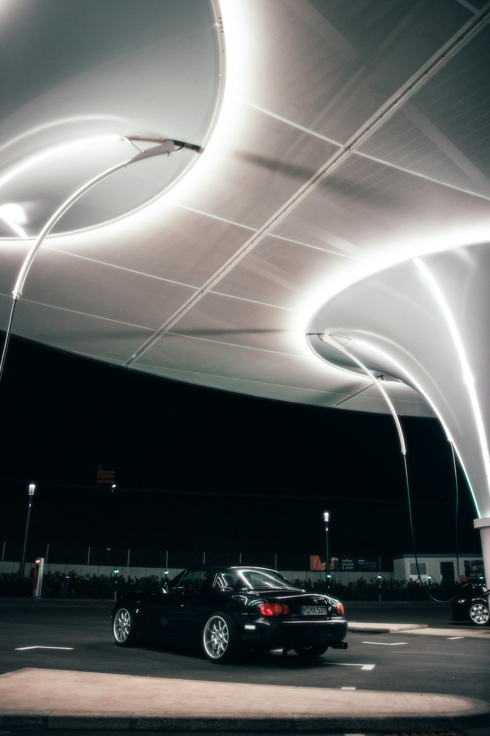 a car is parked under a canopy at night